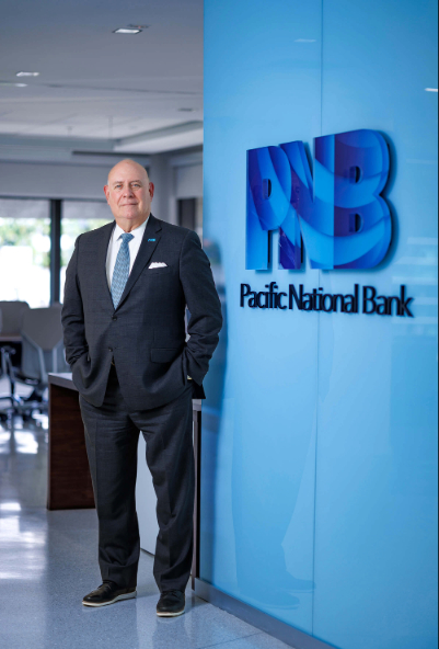 Carlos Fenandez Guzman standing in front of PNB sign